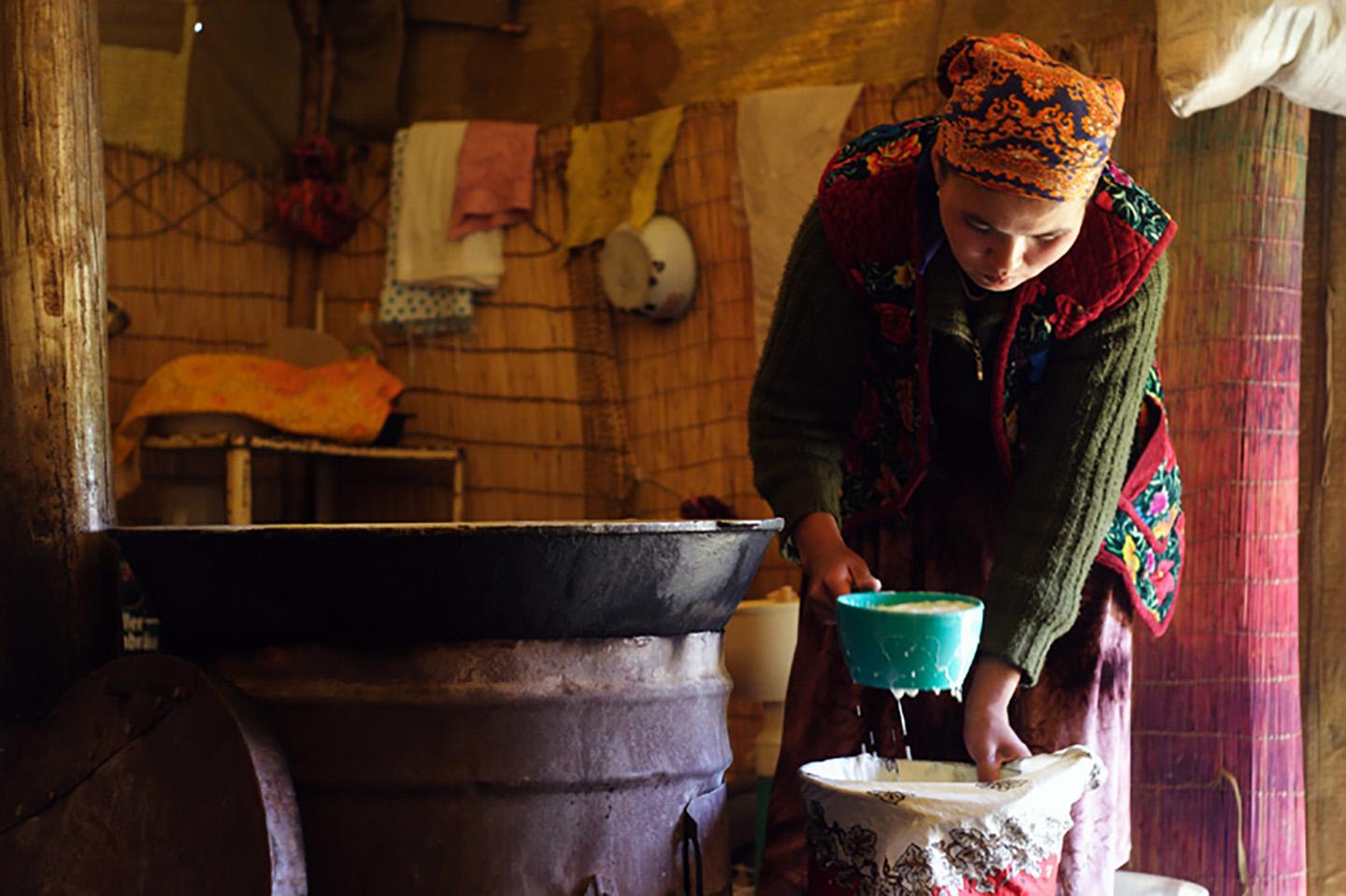 Kyrgyz woman cooking under yurt